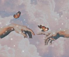 two hands reaching out towards each other in the sky with butterflies flying over them,