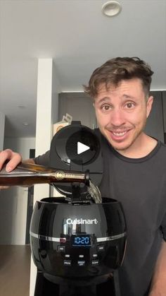 a man standing in front of an air fryer with a digital clock on it