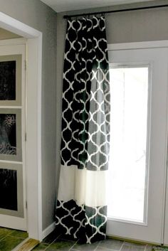 a black and white curtain hanging in front of a window