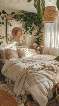 an unmade bed in a bedroom with plants on the wall and hanging lights above it