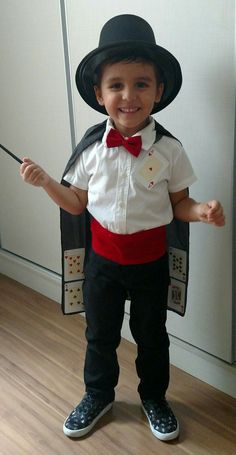 a little boy dressed up in a magician outfit with a top hat and bow tie