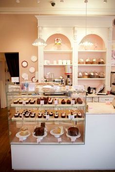 a bakery filled with lots of different types of cakes and cupcakes on display