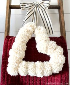 a red blanket with a white heart on it and a bow hanging from the back