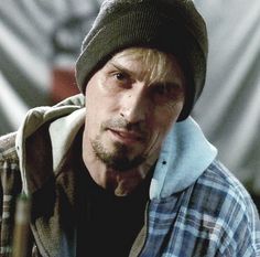 a man wearing a beanie and looking at the camera with an intense look on his face