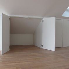 an empty room with white walls and wooden floors