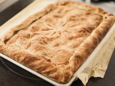 a square baked pastry sitting on top of a table next to a knife and fork