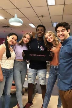 a group of young people standing next to each other posing for a photo in an office