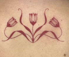 the back of a woman's neck with flowers drawn on her chest and in red ink