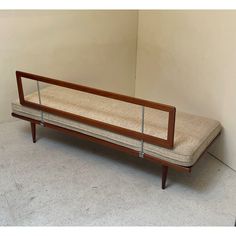 a wooden bench sitting in front of a wall with a mirror on it's back