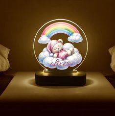 a lamp that has a teddy bear sleeping on top of clouds with a rainbow in the background