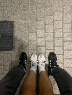 two people standing next to each other with their feet on the ground and one person wearing white shoes