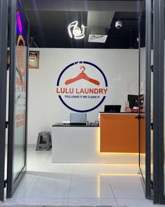 the front entrance to a laundry store with an open door that says luu laundry