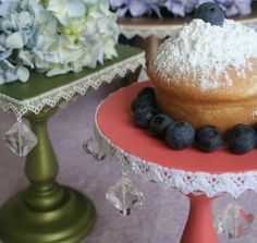 there is a cake with blueberries and powdered sugar on the top next to flowers