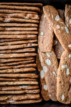 a bunch of cookies that are next to each other on a tray with almonds