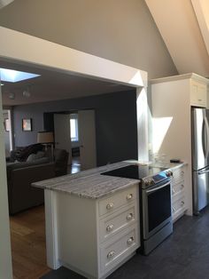 a kitchen with an island, stove and refrigerator freezer combo in it's center