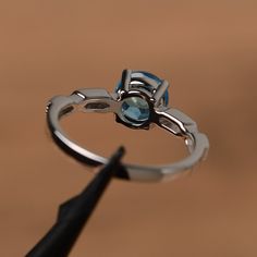 It is a Swiss blue topaz ring. The main stone is 7mm*7mm round cut, weight about 1.66 carats. The basic metal is sterling silver and plated with rhodium. To change the metal to a solid gold (white/rose) or platinum is also available, please ask for a quotation if you want. You can also go to my shop Home for more elegant rings: https://www.etsy.com/shop/godjewelry?ref=hdr_shop_menu Topaz is November birthstone. More topaz rings: https://www.etsy.com/shop/godjewelry?ref=hdr_shop_menu&section_ White Gold Aquamarine Topaz Ring With Prong Setting, Sterling Silver Solitaire Topaz Promise Ring, Sterling Silver Round Topaz Promise Ring, Sterling Silver Topaz Ring With Halo Setting For Promise, Round Cut Topaz Solitaire Promise Ring, White Gold Blue Topaz Birthstone Ring For Promise, Round Cut Solitaire Topaz Promise Ring, White Gold Round Cut Topaz Ring, Silver Topaz Ring With Round Blue Topaz