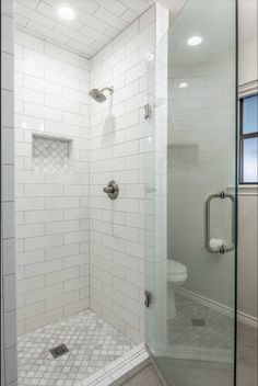 a walk in shower sitting next to a toilet