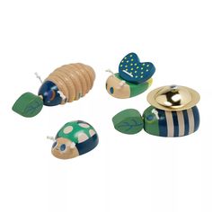 three wooden toys with different designs and colors on them, one has a bug in the middle