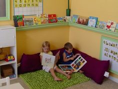 two children are sitting on the floor reading books