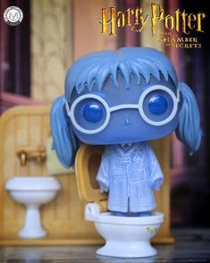 a harry potter figurine sitting on top of a toilet in front of a sink