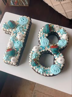 a cake shaped to look like the number 80 on top of a table with blue frosting