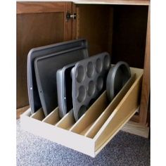 an open cabinet with plates and pans in it