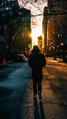 a person walking down the street at sunset