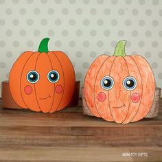 two paper pumpkins sitting on top of a wooden table