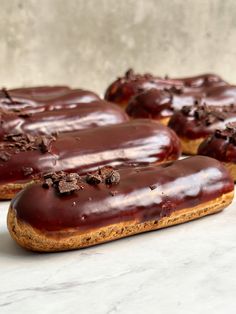 three chocolate covered donuts sitting on top of a counter