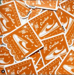 many orange stickers with white designs on them