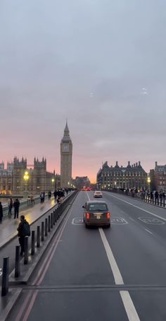 a car driving down the road in front of big ben