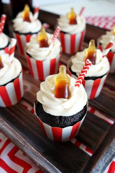 cupcakes with white frosting and caramel toppings on a wooden tray