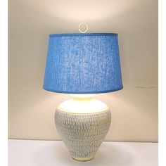 a blue and white lamp sitting on top of a table