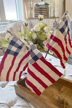 two red, white and blue burlocks on a bed with flowers in the background