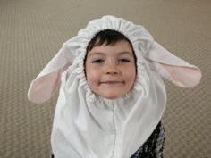 a little boy wearing a bunny costume on top of his head with a blanket over his head