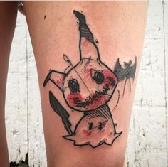 a woman's leg with a tattoo on it that looks like a cartoon character