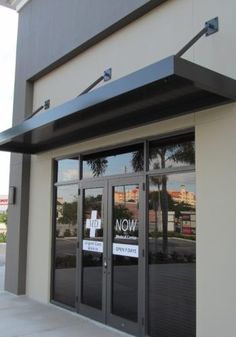 an empty store front with signs on the doors