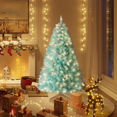 a blue christmas tree in a living room decorated with lights and presents on the floor