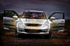 two cars parked side by side in front of each other on a dirt road at night