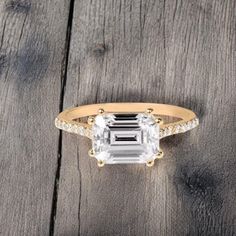 an engagement ring on top of a wooden table with a white diamond in the center