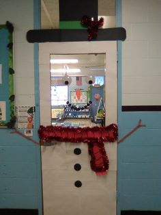 a classroom door decorated for christmas with a snowman on the front and red ribbon