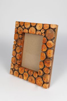 a wooden frame made out of logs with a small square hole in the middle on a white background