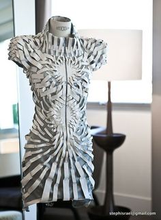 a mannequin made out of newspaper strips on a table next to a lamp