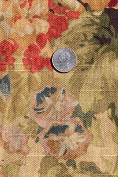 a coin is sitting on top of a floral fabric