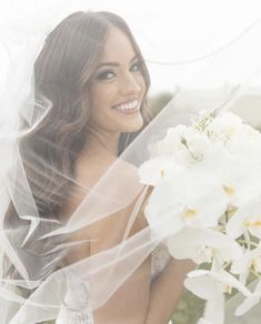 a beautiful woman holding a bouquet of white flowers