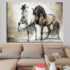 two horses standing next to each other on a wall above a couch in a living room