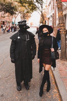 two people dressed in costumes walking down the street