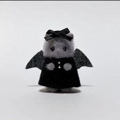 a small stuffed animal wearing a black dress