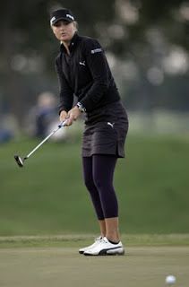 a woman in black shirt and skirt playing golf