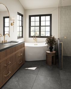 a bathroom with a tub, sink and large window in it's center area